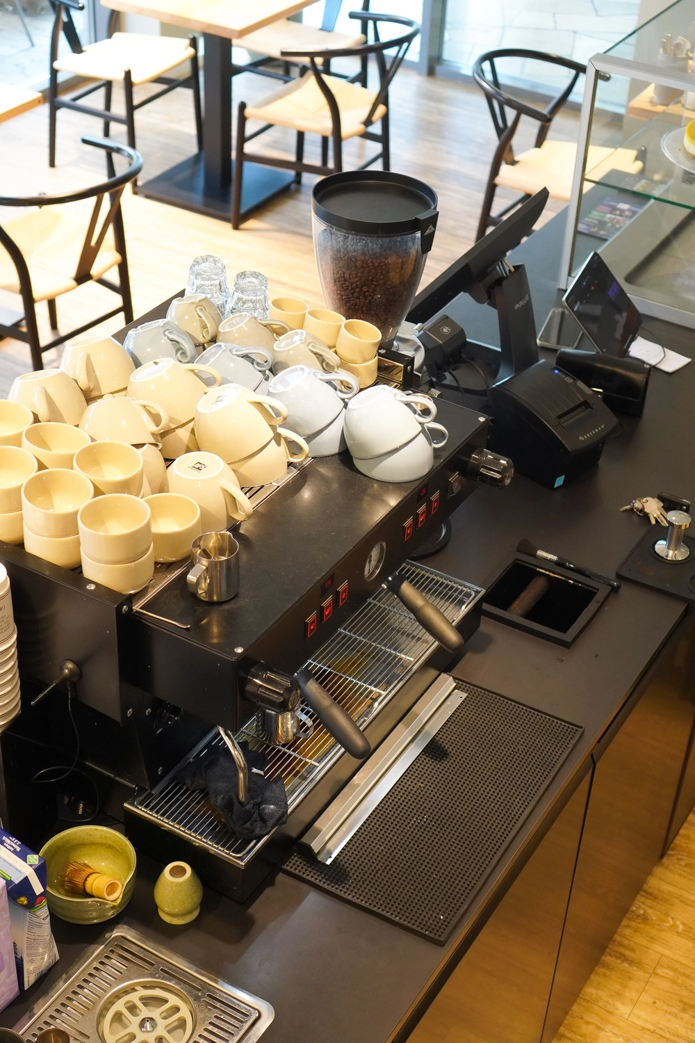 NOA - Café Brunch Konzept - Tassen auf der Kaffeemaschine und hängendes Menüschild